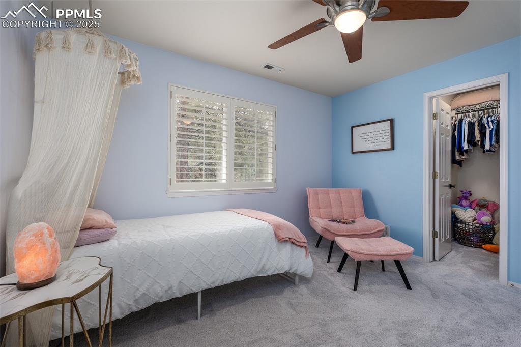 15580 Deercross Court Colorado Springs, CO 80921 - Photo 37 of 50 a bedroom with a bed and a chandelier