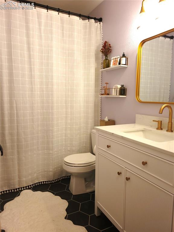 15580 Deercross Court Colorado Springs, CO 80921 - Photo 38 of 50 a bathroom with a sink a toilet and shower curtain