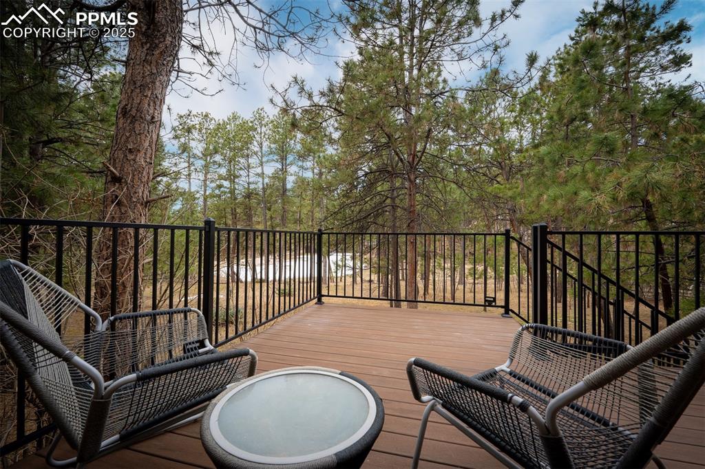 15580 Deercross Court Colorado Springs, CO 80921 - Photo 45 of 50 a balcony with wooden floor table and chairs