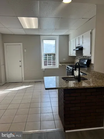 a kitchen with stainless steel appliances a sink stove and cabinets