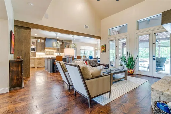 a living room with furniture kitchen view and large windows
