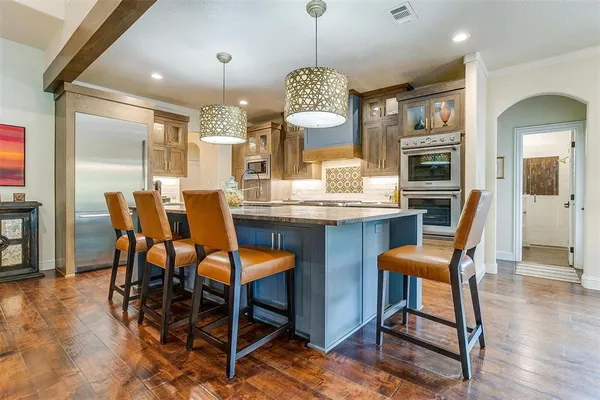 a dining room filled chandelier and wooden floor
