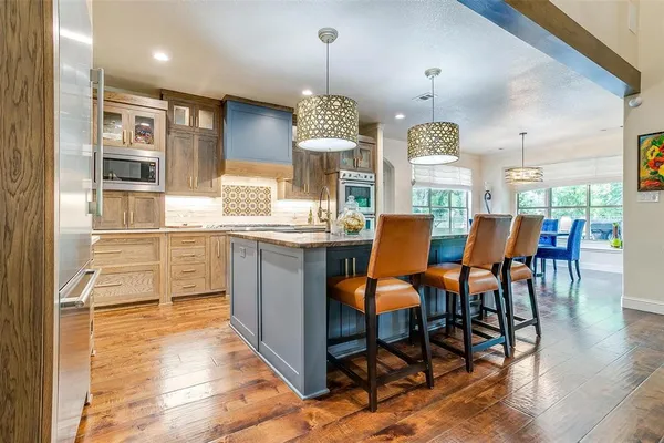 a dining room with stainless steel appliances a table and chairs