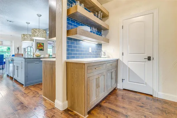 a kitchen with cabinets and wooden floor