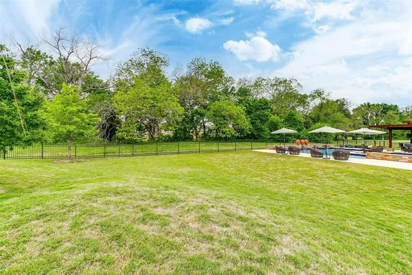 a view of yard with swimming pool and green space