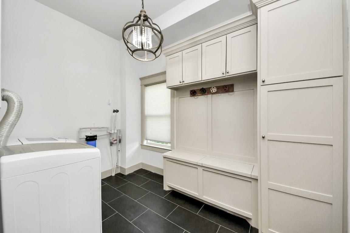 1202 Archer Street Houston, TX 77009 - Photo 25 of 47 This bright laundry room features custom white cabinetry, a washer and dryer, a charming pendant light, and a window providing natural light. Functional storage and modern design make it a practical space for daily chores.