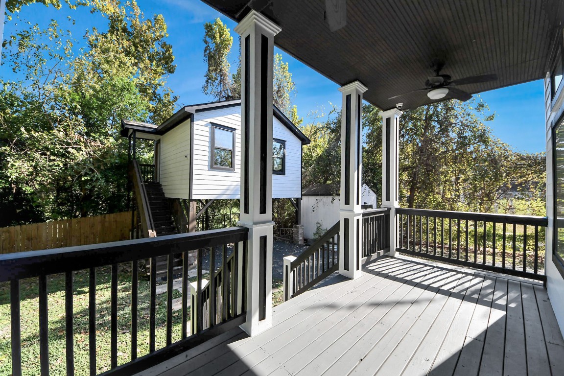 1202 Archer Street Houston, TX 77009 - Photo 10 of 47 This inviting covered porch features elegant railings and a ceiling fan, overlooking a lush, private backyard. A charming detached structure with stairs is nestled among mature trees, creating a serene and cozy outdoor retreat. Elevated tree house offered at 400sqft of living space with staircase access, nestled among trees for
natural privacy. Includes a small shed and gravel driveway, offering practicality and charm.
