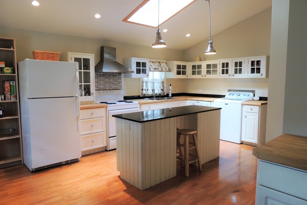 20 Keddy Street Springfield, MA 01109 - Photo 2 of 17 a kitchen with kitchen island a stove a refrigerator a counter top space and cabinets
