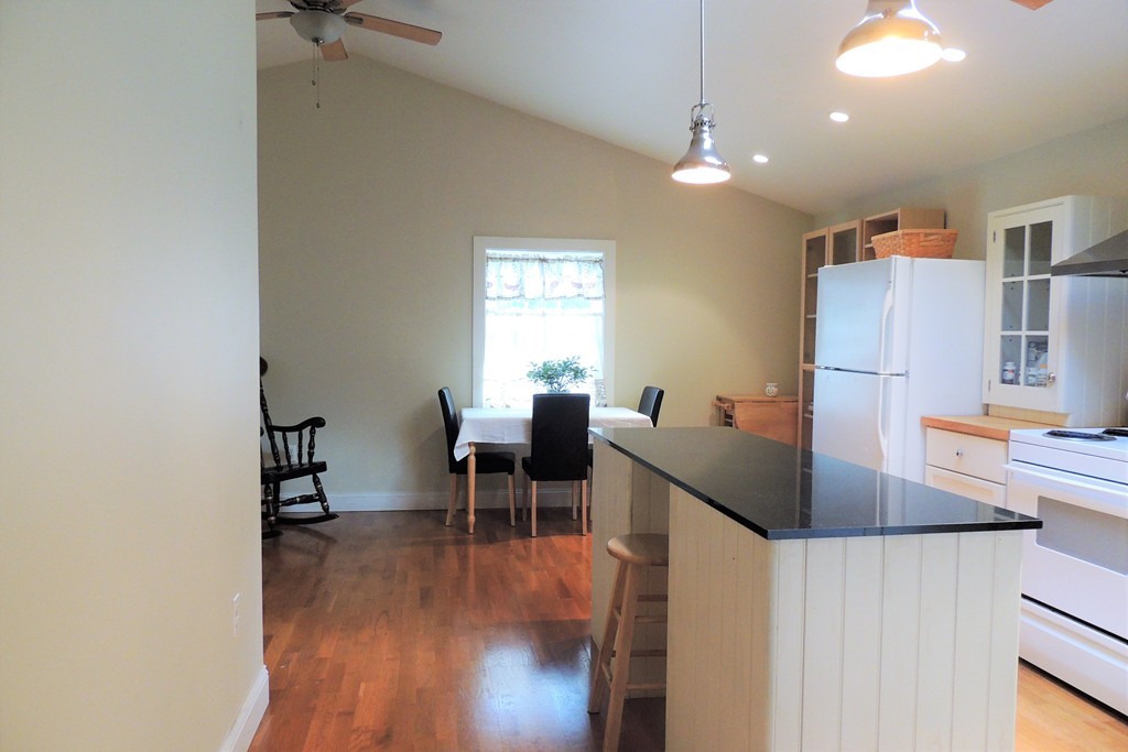 20 Keddy Street Springfield, MA 01109 - Photo 5 of 17 a kitchen with stainless steel appliances granite countertop a stove a refrigerator a dining table and chairs with wooden floor