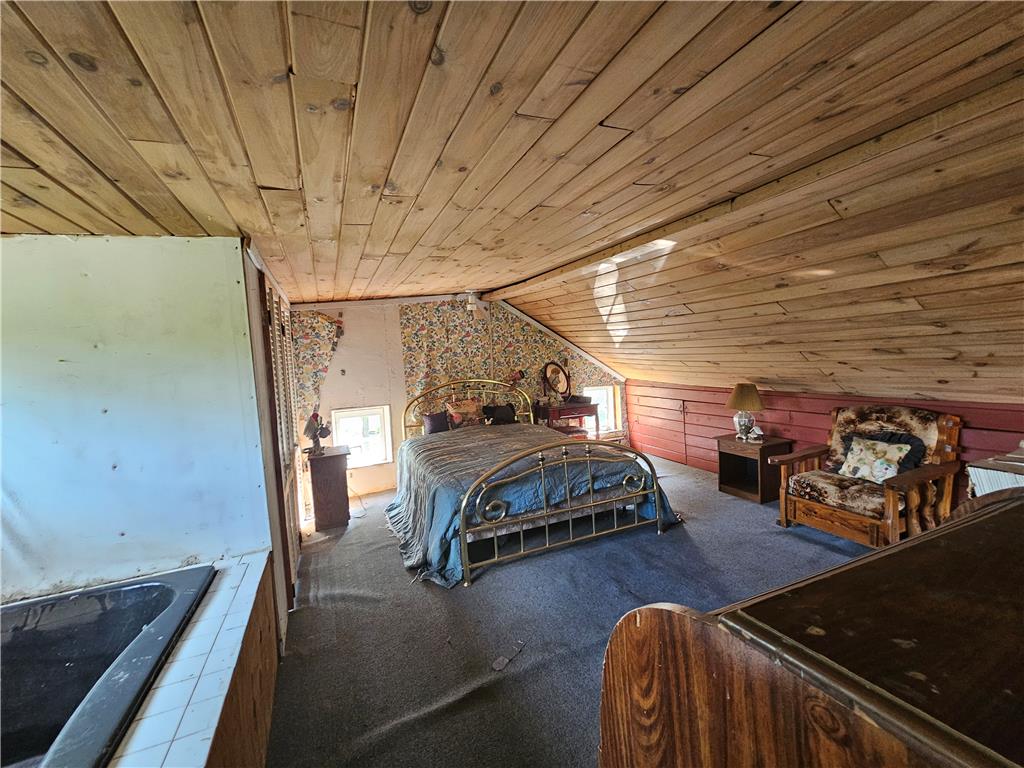 9128 Slateville Road Kempton, PA 19529 - Photo 12 of 13 An inviting bedroom under a wooden sloped ceiling offers a unique, cozy retreat.