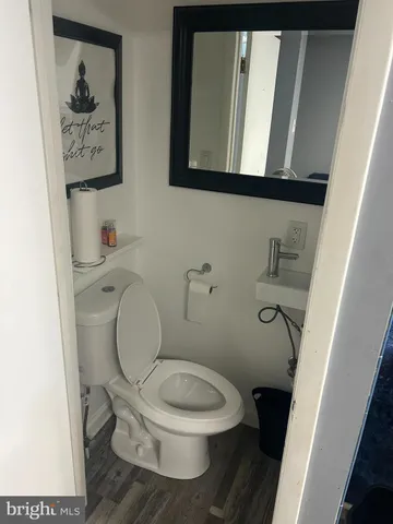 a white toilet sitting next to a small bathroom sink and a toilet