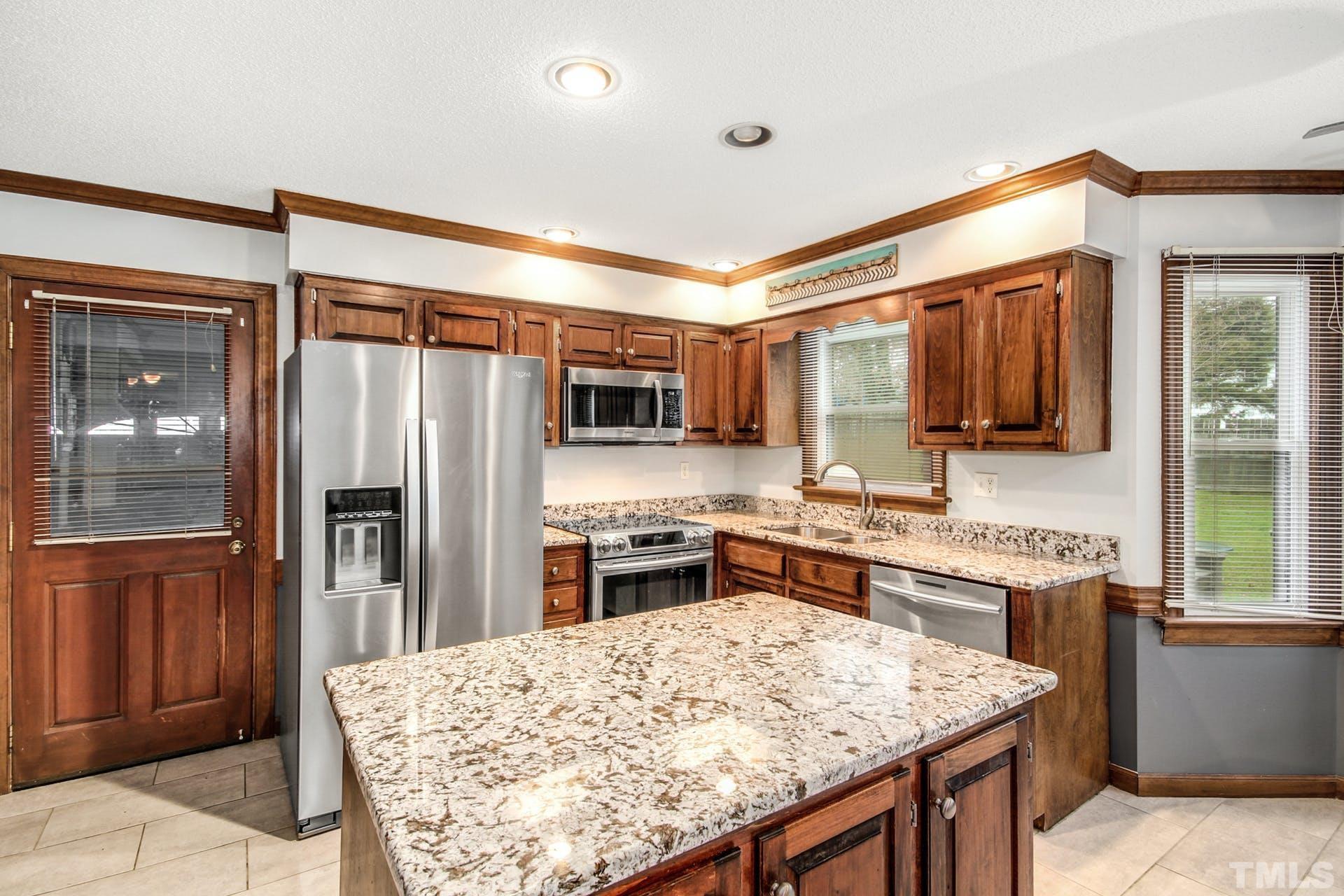 9208 Leesville Road Raleigh, NC 27613 - Photo 8 of 25 a kitchen with stainless steel appliances granite countertop a refrigerator stove and sink