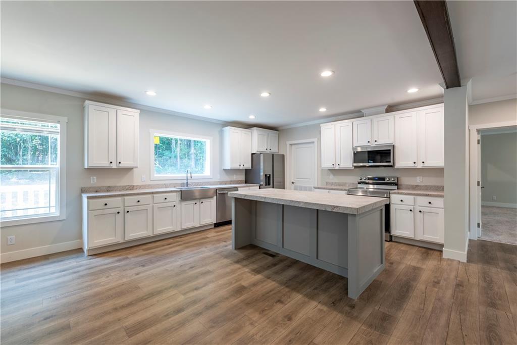 10209 Kelly Bridge Road Dawsonville, GA 30534 - Photo 11 of 31 a kitchen with granite countertop white cabinets and stainless steel appliances