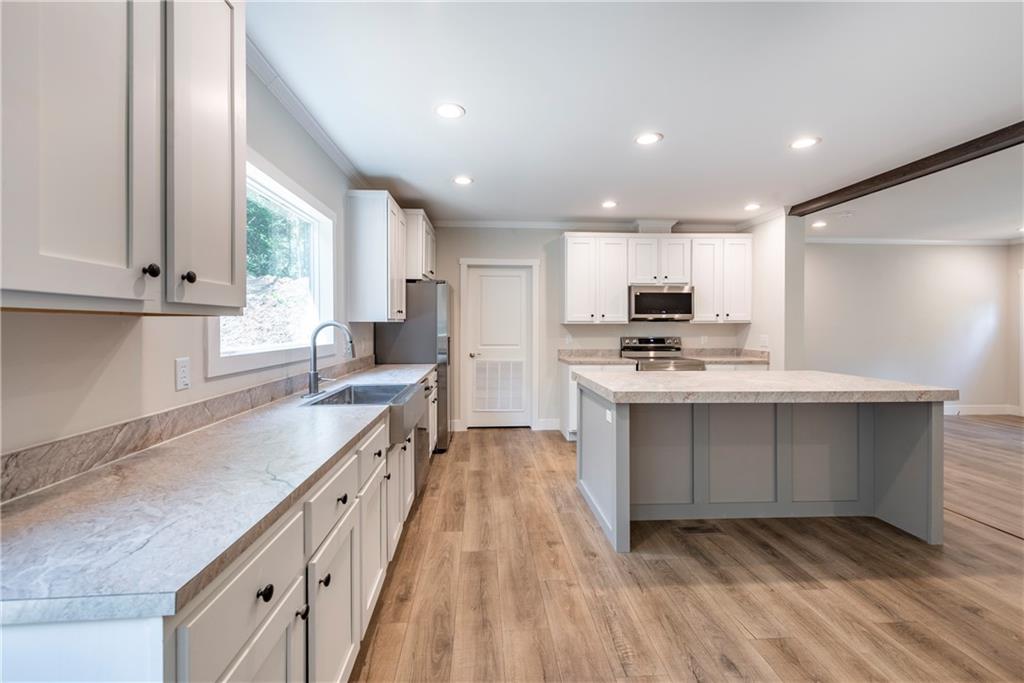 10209 Kelly Bridge Road Dawsonville, GA 30534 - Photo 12 of 31 a kitchen with kitchen island granite countertop a sink cabinets and stainless steel appliances
