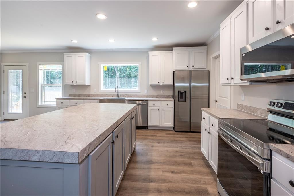 10209 Kelly Bridge Road Dawsonville, GA 30534 - Photo 13 of 31 a kitchen with stainless steel appliances granite countertop a sink stove refrigerator and cabinets