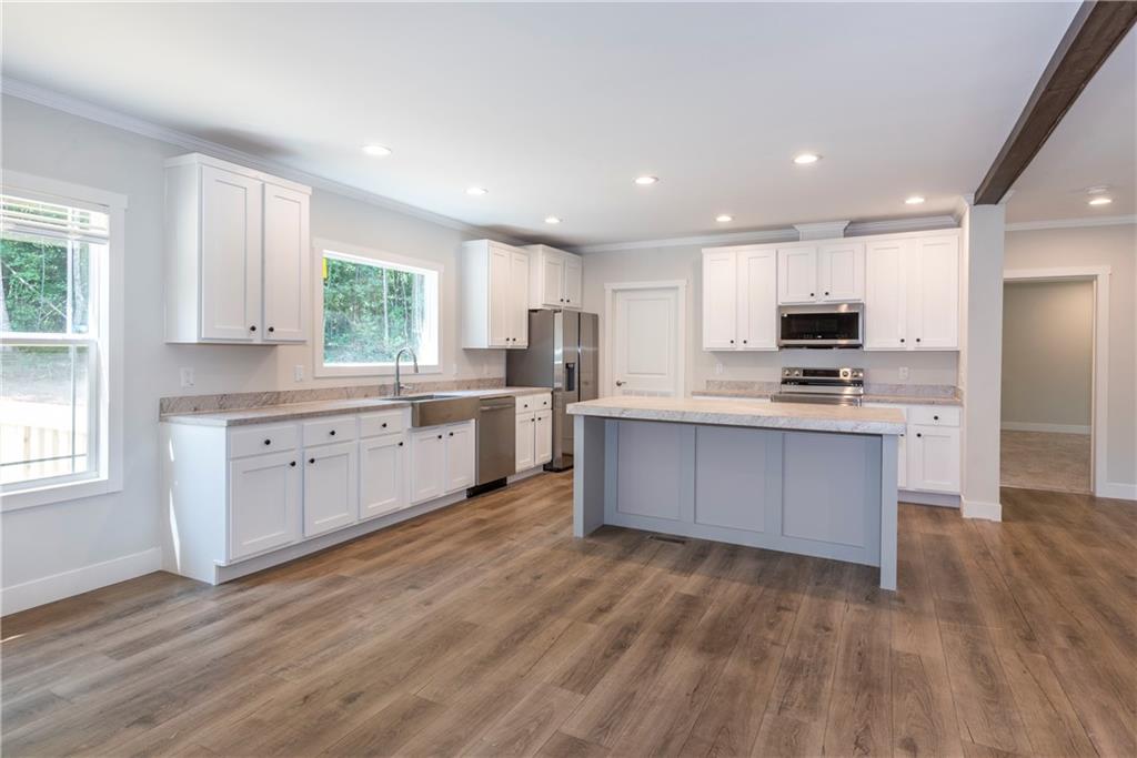 10209 Kelly Bridge Road Dawsonville, GA 30534 - Photo 16 of 31 a large kitchen with stainless steel appliances granite countertop a stove a sink dishwasher a microwave oven and a refrigerator with wooden floor