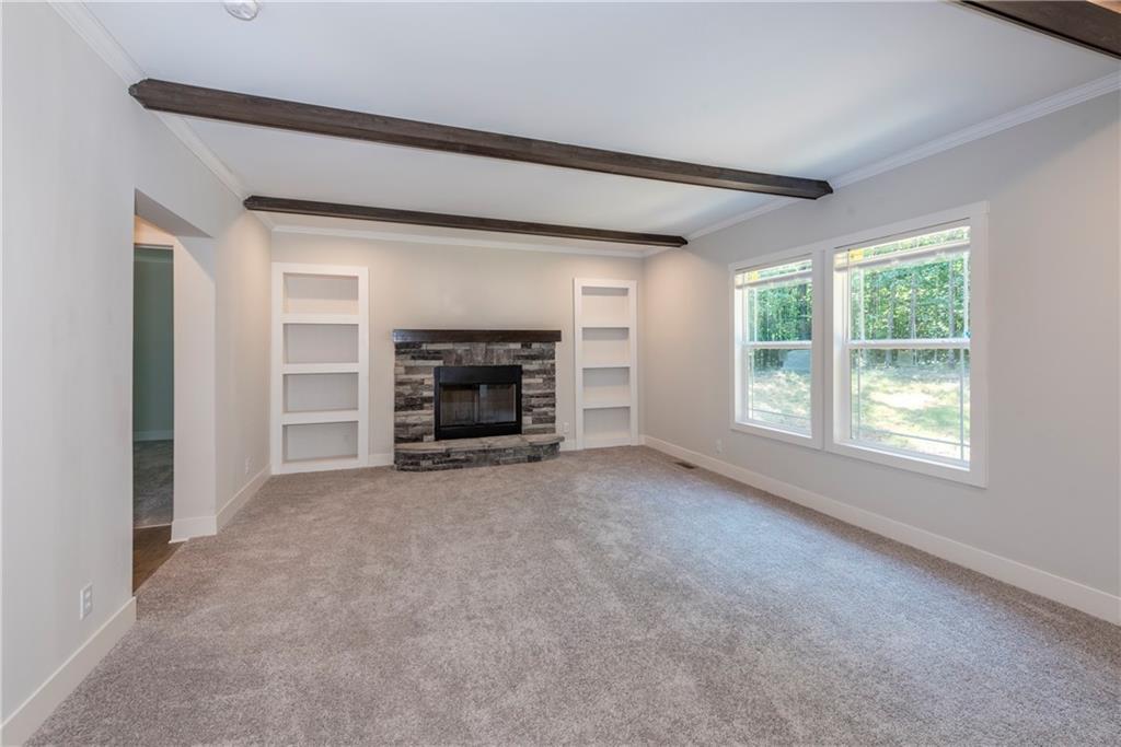 10209 Kelly Bridge Road Dawsonville, GA 30534 - Photo 18 of 31 an empty room with furniture and a fireplace
