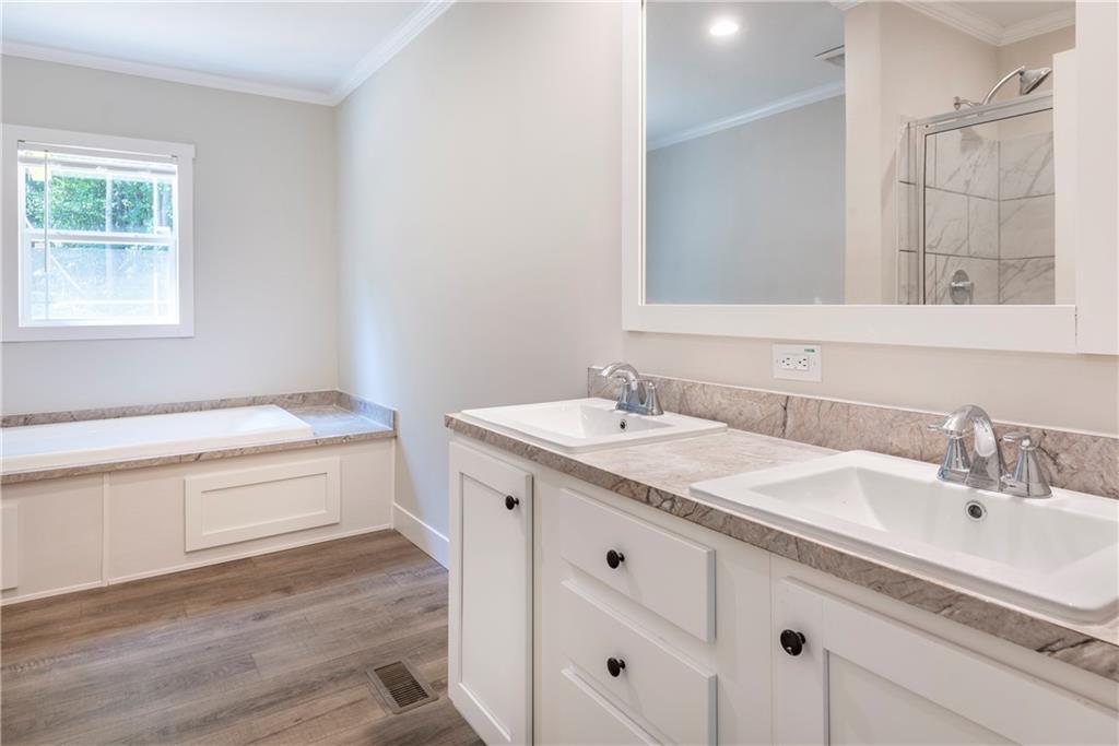 10209 Kelly Bridge Road Dawsonville, GA 30534 - Photo 24 of 31 a bathroom with a granite countertop sink and a bathtub