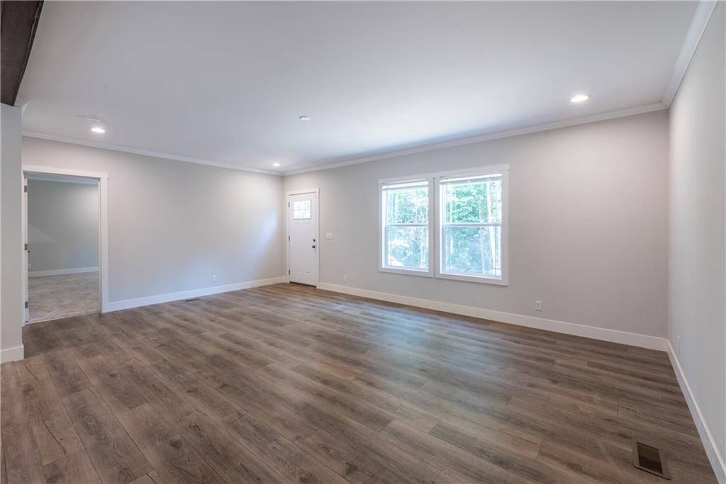 10209 Kelly Bridge Road Dawsonville, GA 30534 - Photo 9 of 31 an empty room with wooden floor and windows
