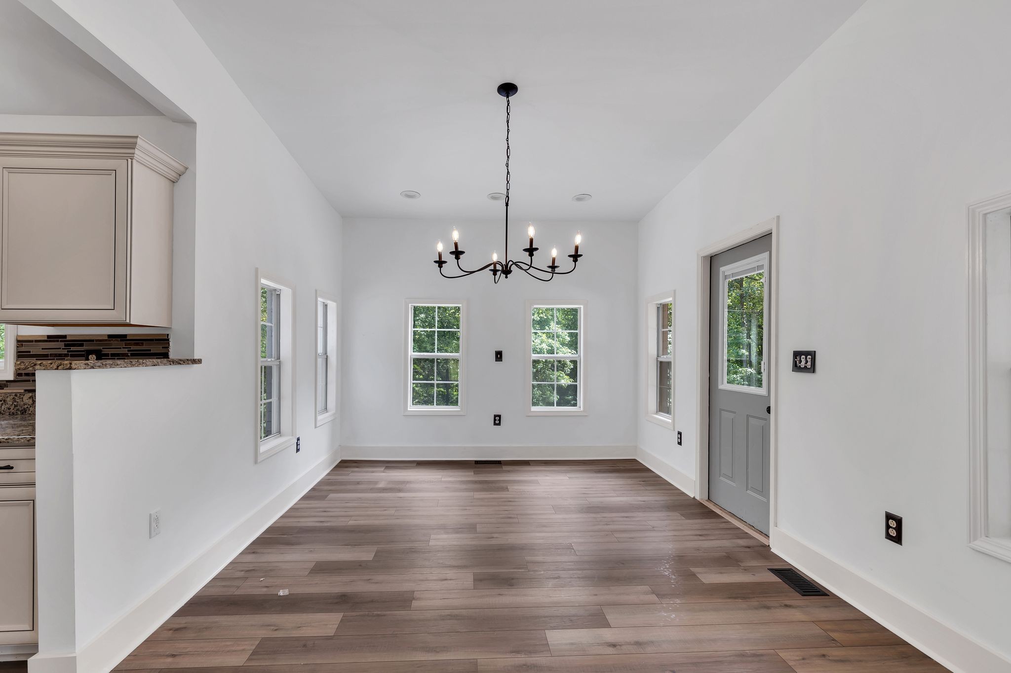 1450 Southside Road Southside, TN 37171 - Photo 18 of 41 a view of an empty room with window wooden floor and a kitchen