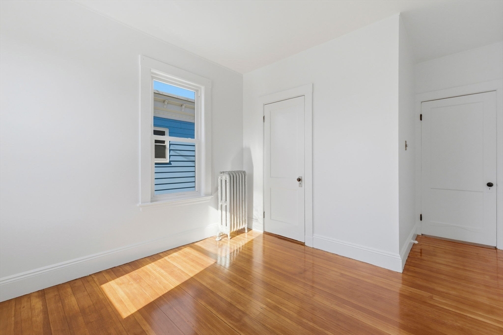 9 Sumner Square Boston, MA 02125 - Photo 4 of 10 a view of empty room with wooden floor and fan