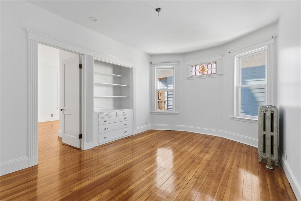 9 Sumner Square Boston, MA 02125 - Photo 5 of 10 wooden floor in an empty room with a window