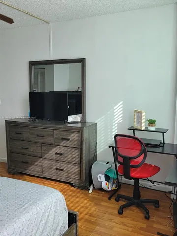 a bedroom with a bed a bookshelf and a chair