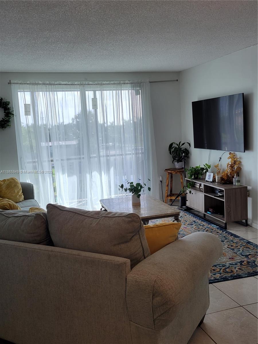 919 Hillcrest Drive, Unit 306 Hollywood, FL 33021 - Photo 15 of 30 a living room with furniture and a flat screen tv