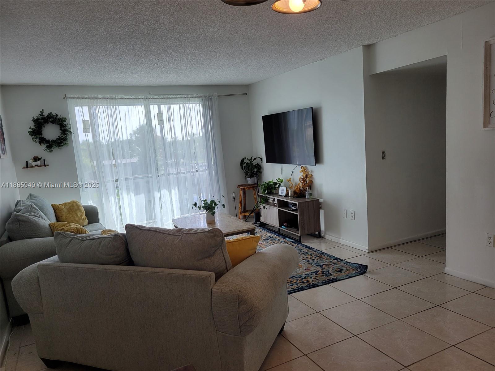 919 Hillcrest Drive, Unit 306 Hollywood, FL 33021 - Photo 2 of 30 a living room with furniture and a flat screen tv