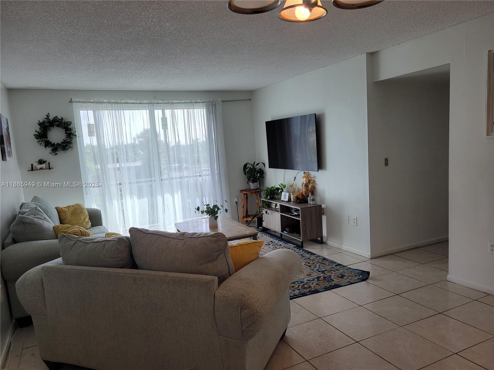 919 Hillcrest Drive, Unit 306 Hollywood, FL 33021 - Photo 3 of 30 a living room with furniture and a flat screen tv