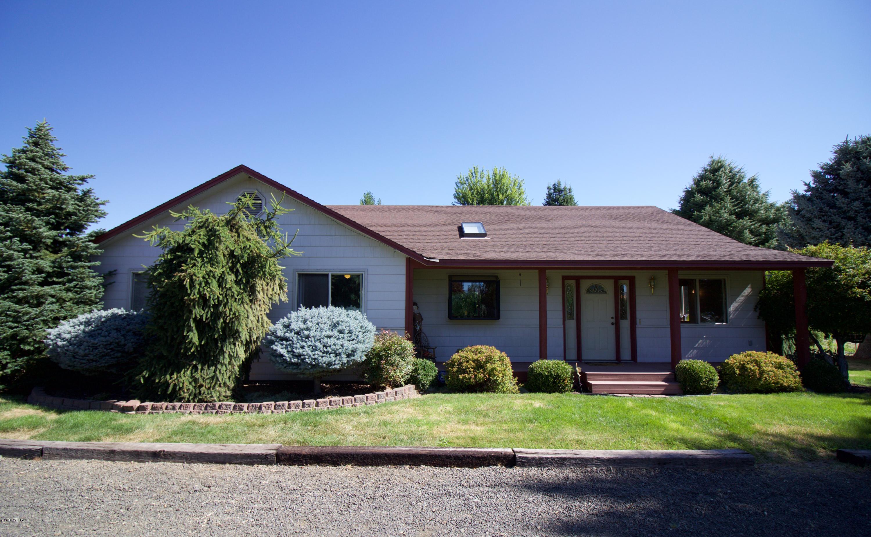 12831 Nelson Road Yakima, WA 98903 - Photo 1 of 24 a front view of a house with a garden and plants