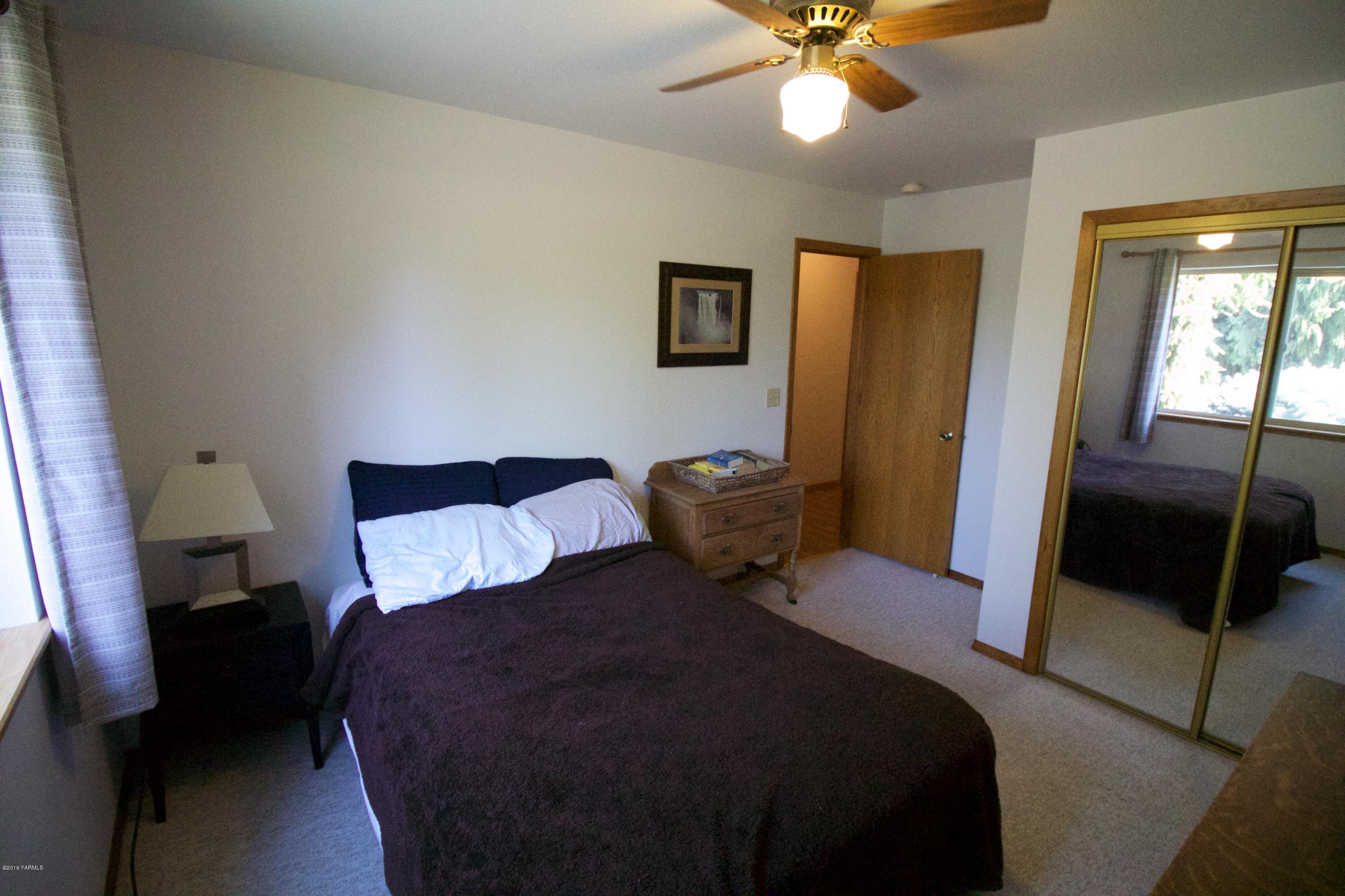 12831 Nelson Road Yakima, WA 98903 - Photo 16 of 24 a bedroom with a bed and a chandelier