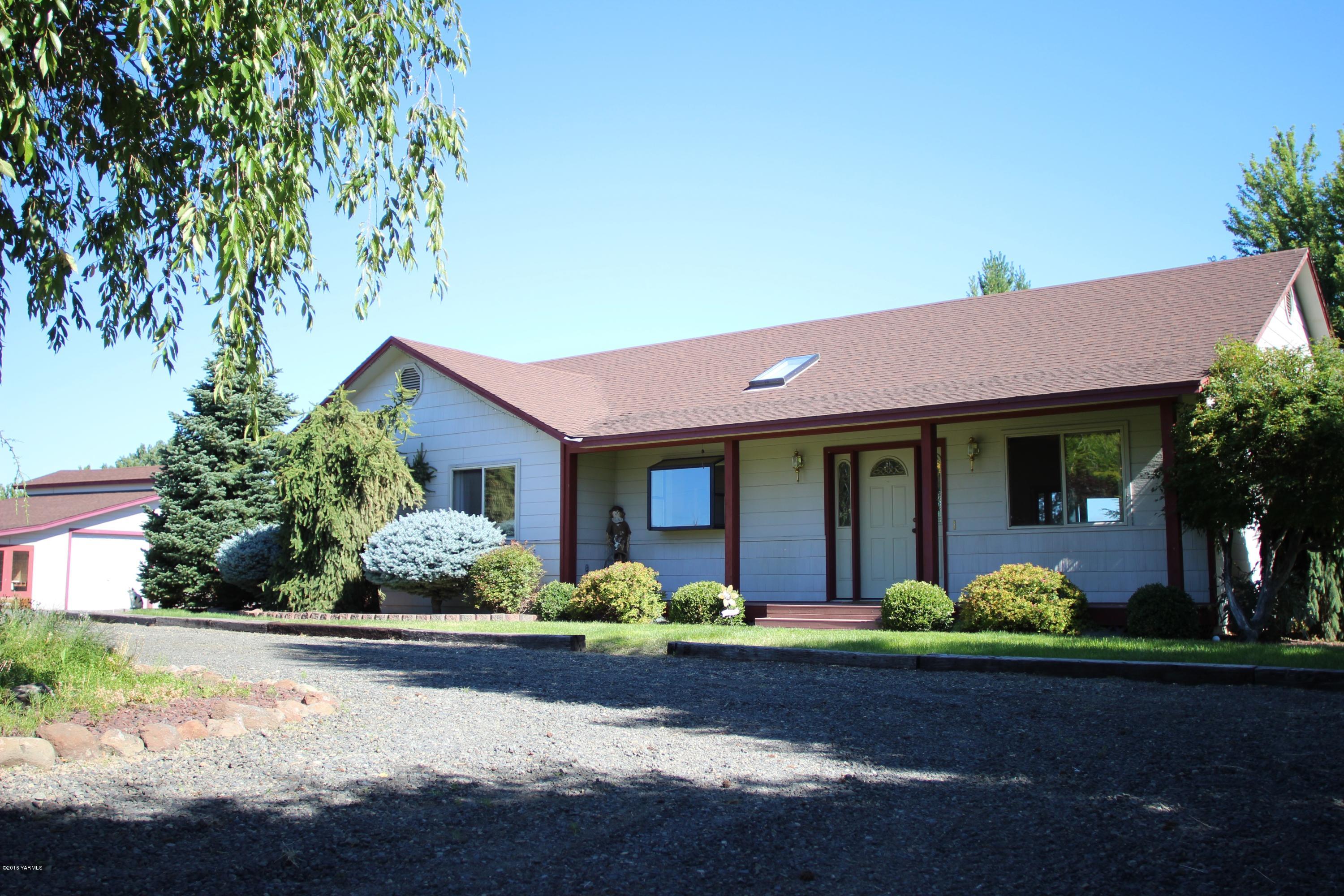 12831 Nelson Road Yakima, WA 98903 - Photo 23 of 24 a front view of a house with lots of trees and flowers