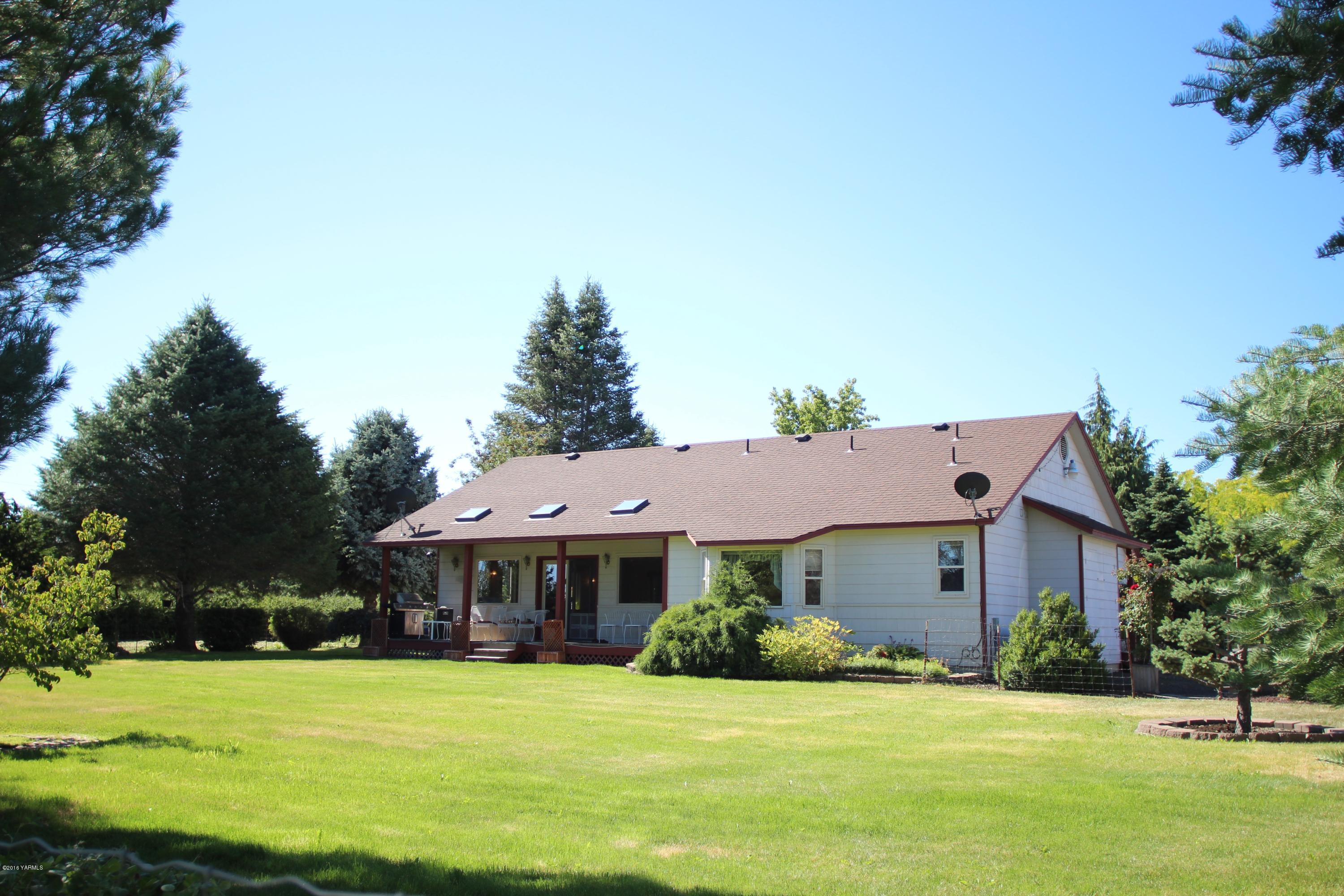 12831 Nelson Road Yakima, WA 98903 - Photo 5 of 24 a front view of a house with a garden