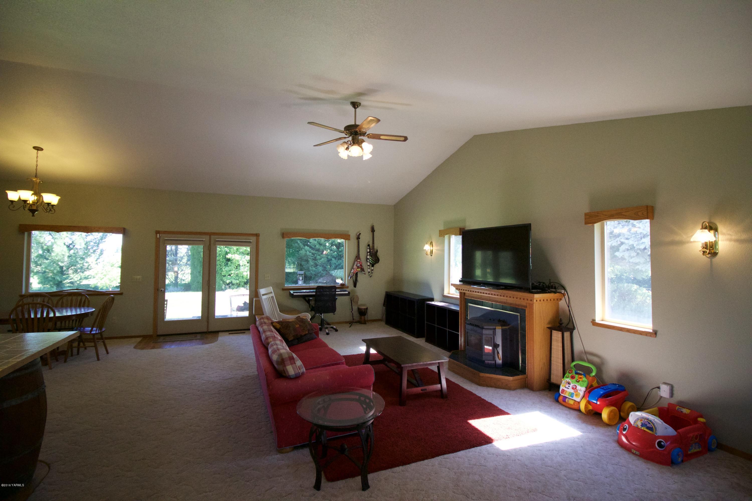 12831 Nelson Road Yakima, WA 98903 - Photo 7 of 24 a living room with furniture a flat screen tv and a fireplace