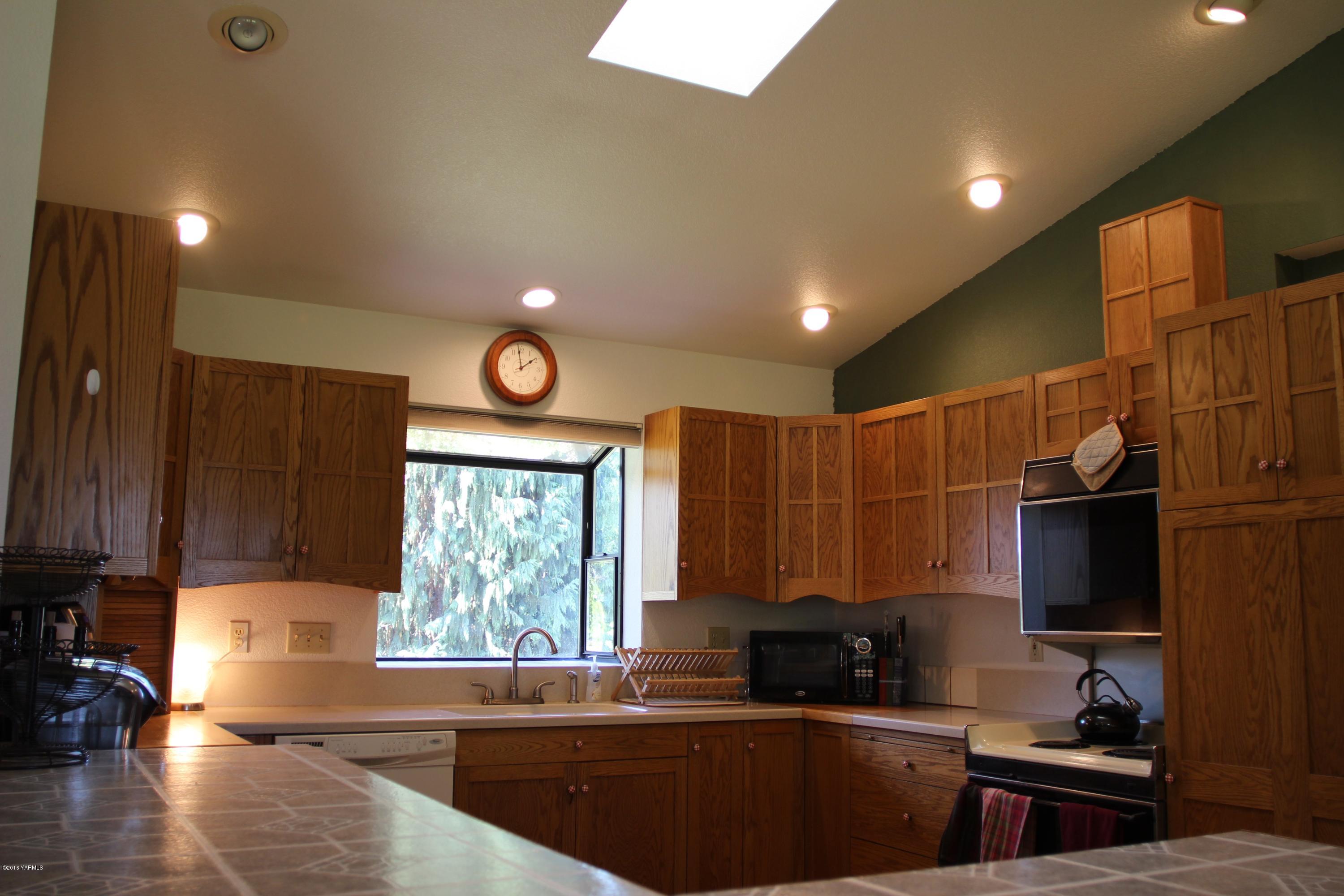 12831 Nelson Road Yakima, WA 98903 - Photo 10 of 24 a kitchen with granite countertop a sink a window stainless steel appliances and cabinets