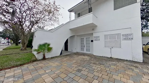 a view of a house with a yard and potted plants