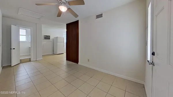an empty room with closet and a chandelier fan