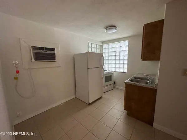 a kitchen with a refrigerator and a stove top oven