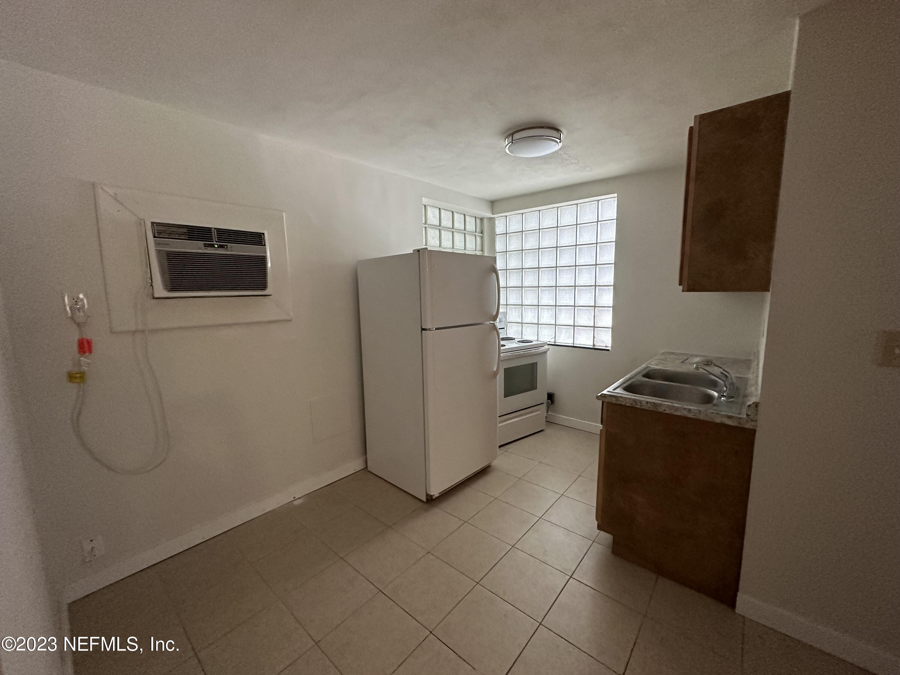 1824 Hendricks Avenue, Unit 1 Jacksonville, FL 32207 - Photo 4 of 11 a kitchen with a refrigerator and a stove top oven