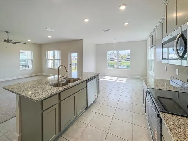 a kitchen with stainless steel appliances granite countertop a sink stove and cabinets
