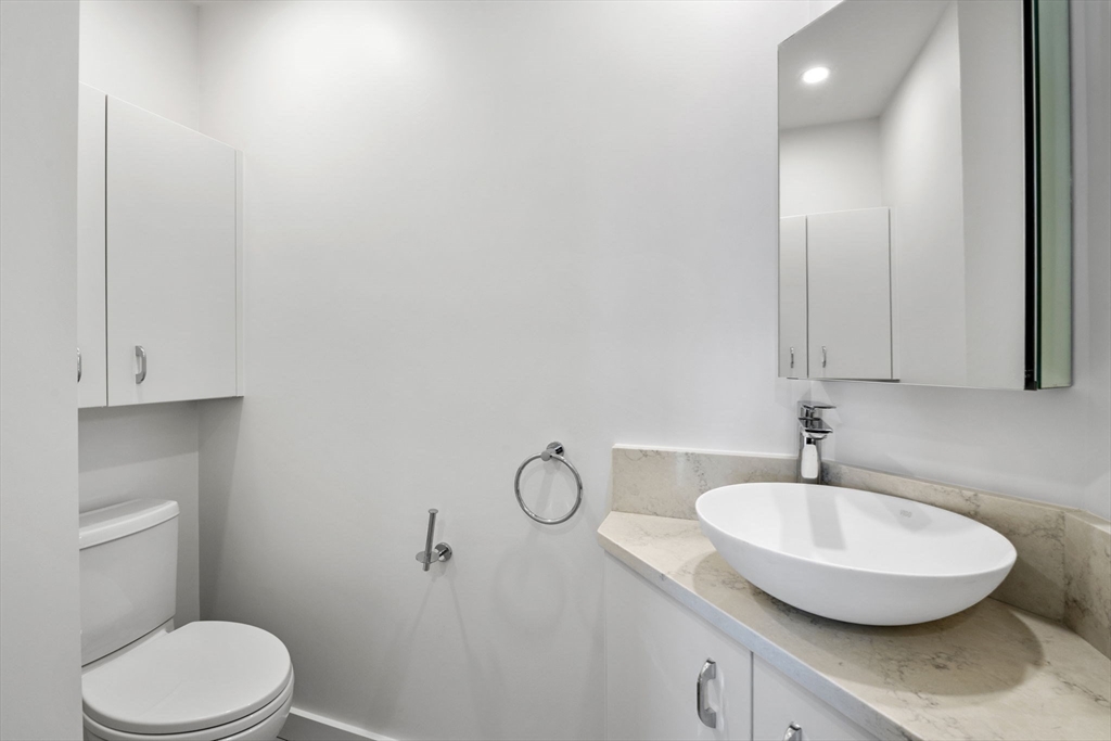 34 Constitution Way, Unit D Marblehead, MA 01945 - Photo 15 of 33 a bathroom with a granite countertop sink and a mirror