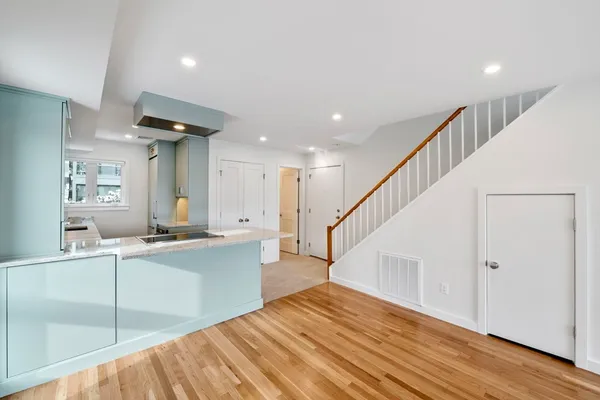a view of a kitchen with cabinets and wooden floor