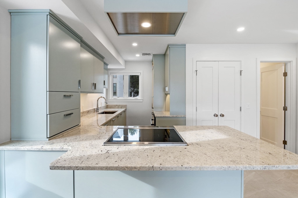 34 Constitution Way, Unit D Marblehead, MA 01945 - Photo 7 of 33 a kitchen with kitchen island granite countertop a sink and white cabinets