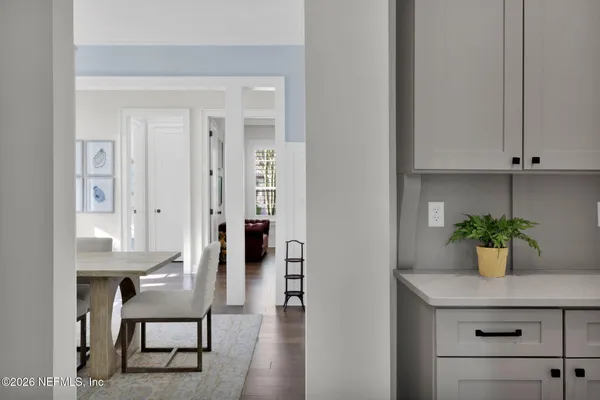 a view of a dining room with furniture a chandelier and wooden floor
