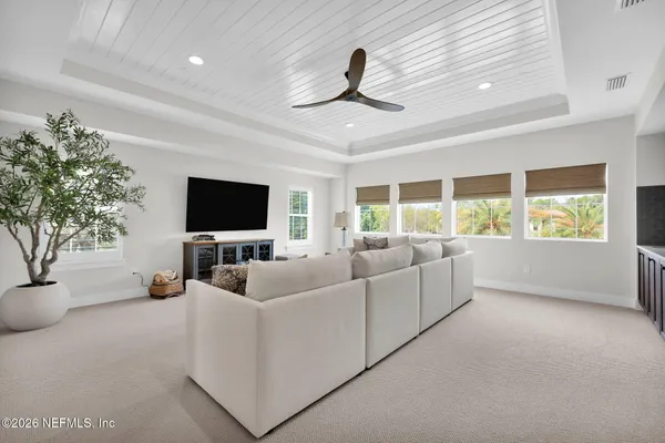 a living room with patio furniture and a floor to ceiling window