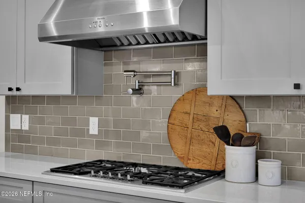 a kitchen with stainless steel appliances kitchen island granite countertop a dining table chairs and white cabinets