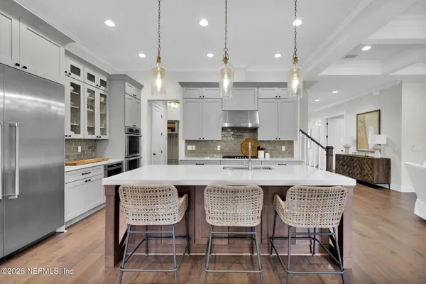 a kitchen with stainless steel appliances white cabinets and wooden floor