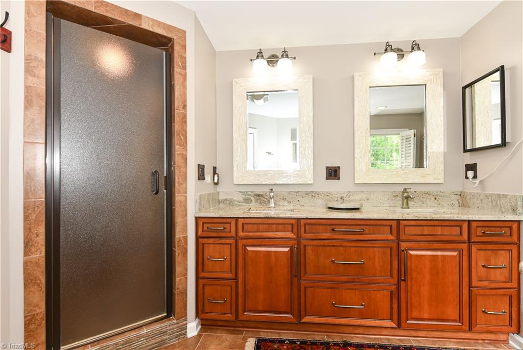 8305 Case Ridge Drive Oak Ridge, NC 27310 - Photo 37 of 48 Beautiful updated primary bath, with custom cabinets, separate shower and jetted tub.