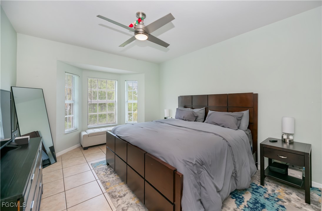 8513 Bernwood Cove Loop, Unit 212 Fort Myers, FL 33966 - Photo 14 of 43 a bedroom with a bed a dresser and a window